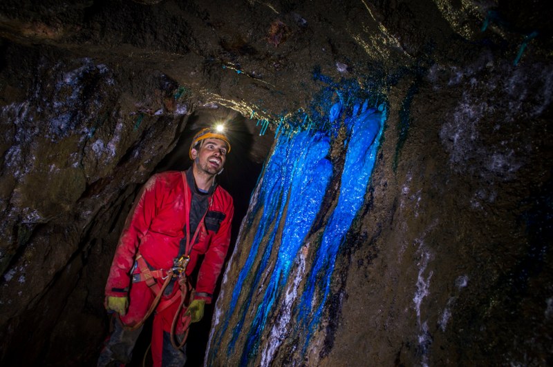 Mine explorer awed by beautiful blue mineral formations in a Cornish tin mine.