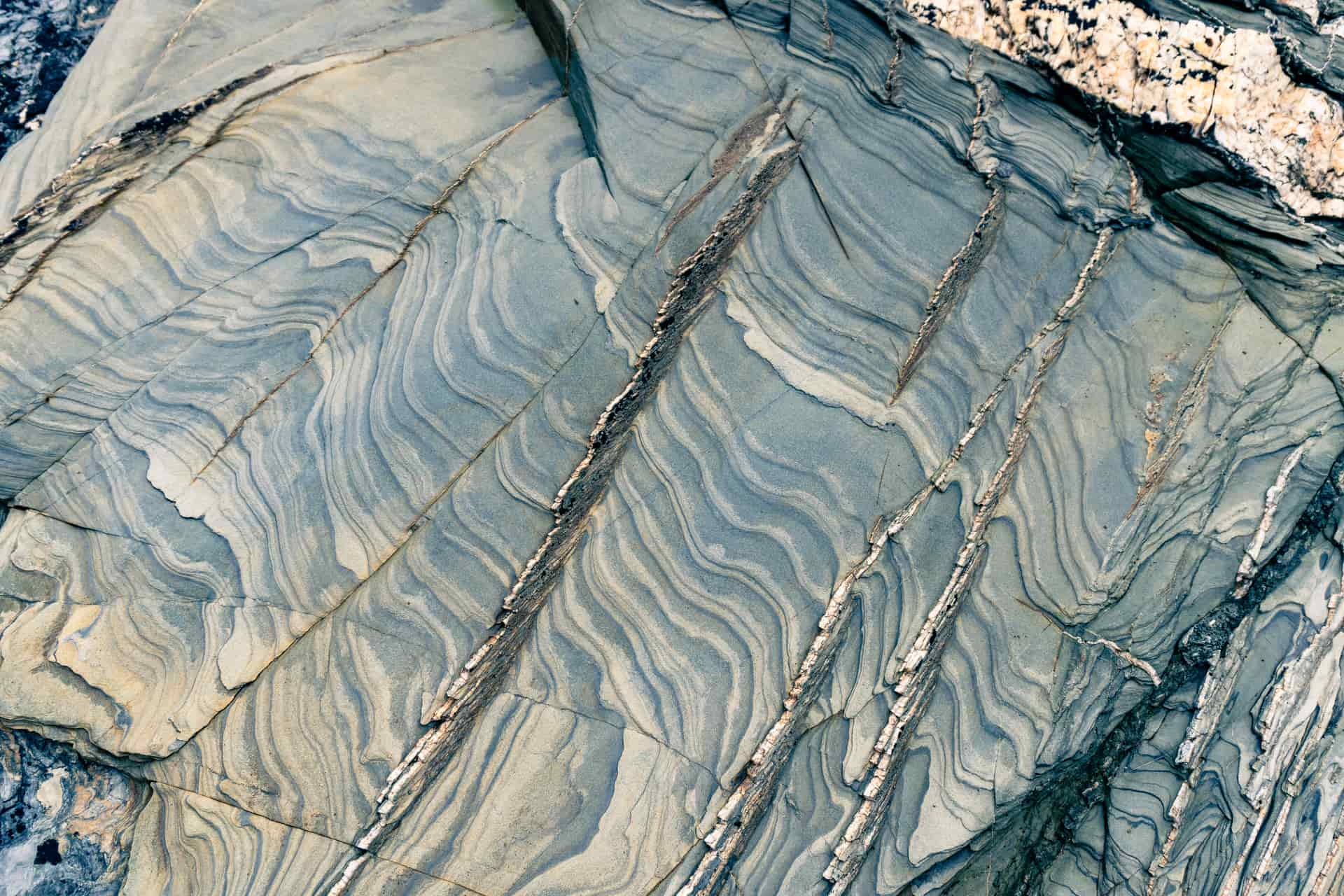 Sandstone layering and deformed quartz veins in killas rock at Fishing Cove, Godrevy, Cornwall