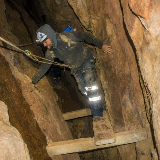 The Underground Adventurer Mine explorer climbing a mineshaft near St. Just, Cornwall