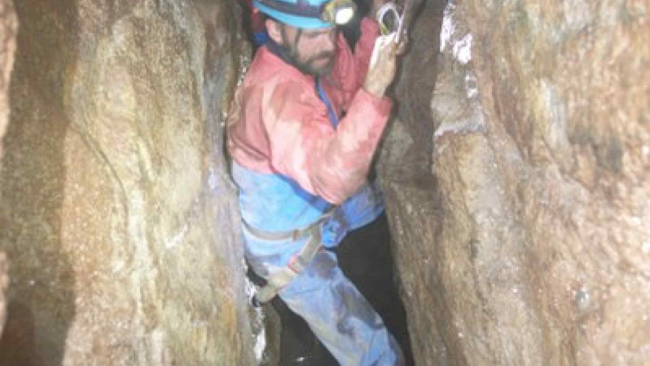 USing cvaing techniques to explore Cornwallis tin mines, here a group traverses a deep shaft using ropes in Cornwall.