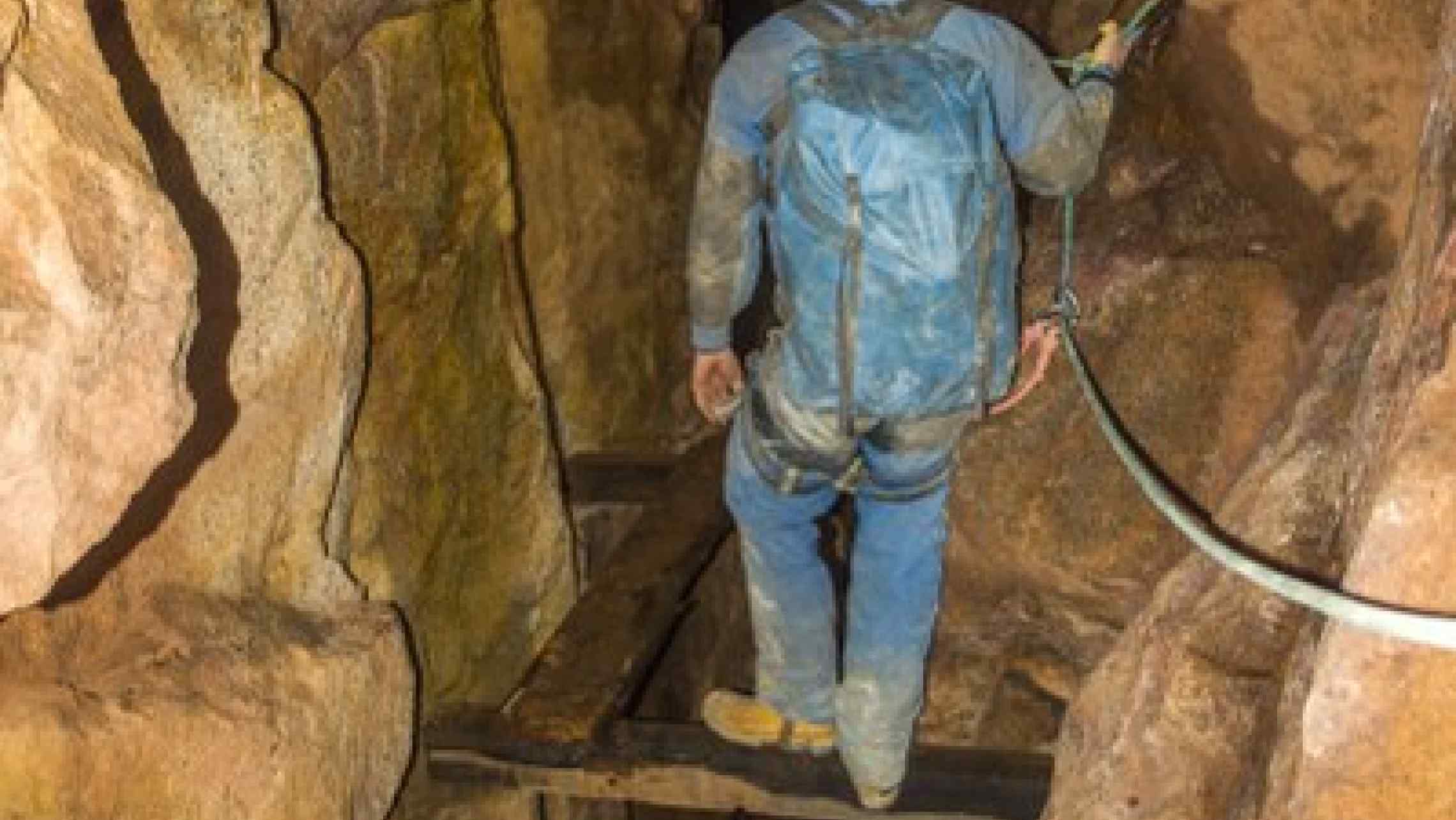 Cornish mine explorer casually traverses huge mine shaft in a west Cornwall tin mine. Adventure near the Crowns Mine, Botallack, Geevor, Wheal Leisure, Poldark, Levant.