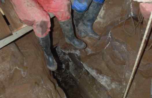 Mine explorers abseiling deep in a Cornish tin mine near St. Ives