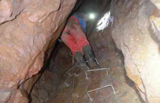 Mine explorers descending ladders on a trip deep into a Cornish tin mine.